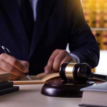 Lawyer writing down notes while meeting with a prospective client.