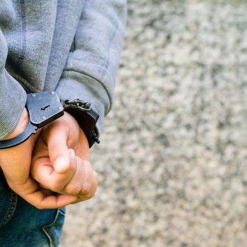 Closeup of a juvenile being in handcuffs after getting in legal trouble