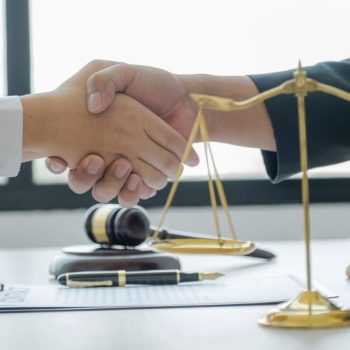 Two lawyers shaking hands after agreeing to a plea bargain