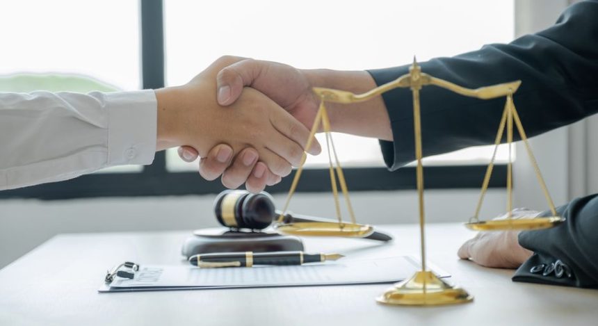 Two lawyers shaking hands after agreeing to a plea bargain